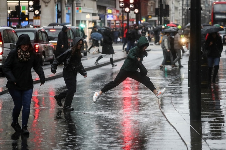 Los peatones tratan de evitar un charco mientras caminan por Oxford Street durante la tormenta Dennis en Londres