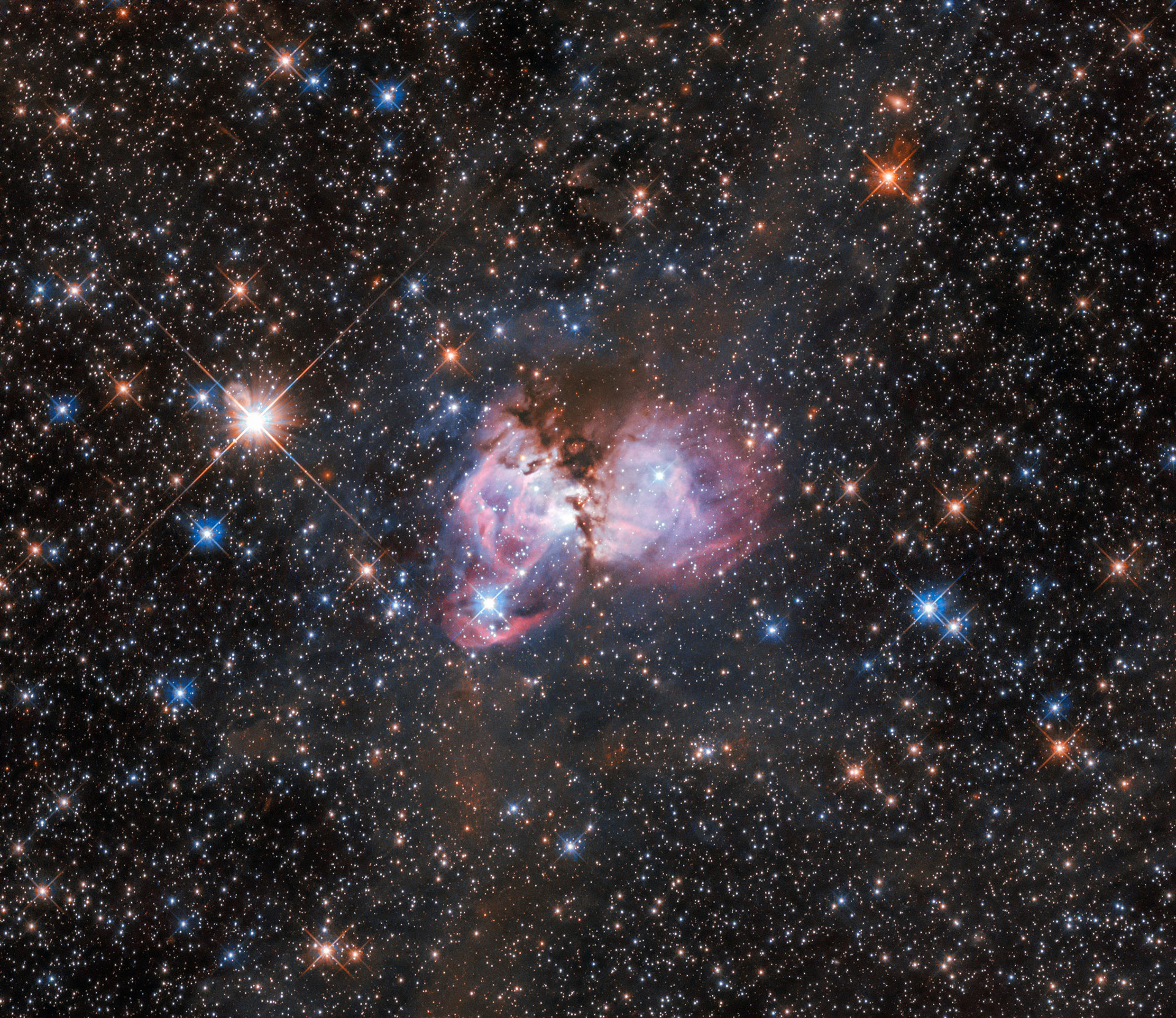 Esta escena de creación estelar, capturada por el Telescopio Espacial Hubble, se encuentra cerca de las afueras de la famosa Nebulosa de la Tarántula, la mayor guardería estelar conocida en el universo local