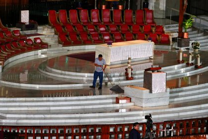 Un trabajador limpia el piso antes que el cardenal de la iglesia Católica mexicana, Carlos Aguiar, celebre una misa a través de YouTube, en Ciudad de México (Foto: Reuters/Henry Romero)