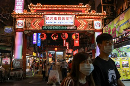 Taiwaneses usan mascarillas para prevenir la propagación de la enfermedad del coronavirus (COVID-19) mientras pasean por un mercado nocturno en Taipei, Taiwán (Reuters)