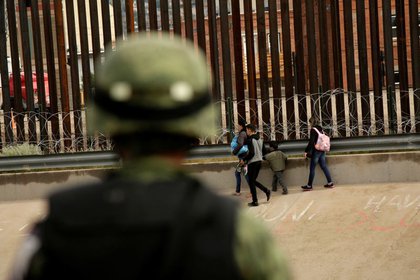 Un soldado de la Guardia Nacional observa a un grupo de migrantes después de cruzar ilegalmente a El Paso, Texas, para entregarse a agentes de la Patrulla Fronteriza (Foto: Reuters)