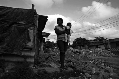 Una mujer carga un bebé en el barrio marginal de La María, en Cartagena (Colombia). EFE/Paolo Aguilar/Archivo
