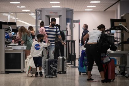 Una familia usa mascarillas al pasar la seguridad en la Terminal A del Aeropuerto Intercontinental George Bush en medio del brote de la enfermedad coronavirus (COVID-19) en Houston, Texas, Estados Unidos (REUTERS/Adrees Latif/Archivo)