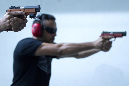 Dos hombres disparan armas de fuego en un campo de tiro, el 1 de octubre de 2020, en la ciudad de Valparaíso, en el estado de Goias (Brasil). EFE/ Joedson Alves
