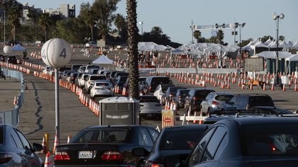 Los residentes de Los Ángeles esperan en fila en sus coches durante la madrugada para recibir la vacuna contra el covid-19 en el estadio de los Dodgers, en Los Ángeles