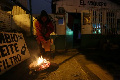 Un hombre se calienta con una fogata durante un frente frío en Matamoros, México 18 de febrero de 2021 (Foto: REUTERS/Daniel Becerril)