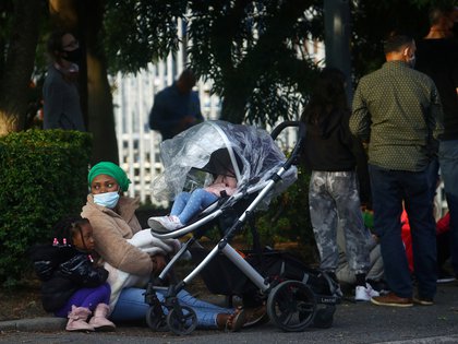 Una mujer con sus hijos se sienta fuera de un centro de pruebas de coronavirus en Southend-on-sea, Reino Unido, (REUTERS/Hannah McKay)