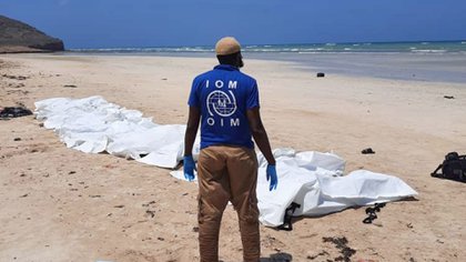  Un trabajador de la Organización Internacional para las Migraciones (OIM) observa los cuerpos de presuntos migrantes que murieron después de que su barco volcó frente a la costa de Djibouti el 12 de abril de 2021. (Reuters)