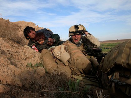 Chris Sanderson, de 24 años, de Flemington, Nueva Jersey, de la Marina de los EE. UU., grita mientras intenta proteger a un afgano y a su hijo después de que combatientes talibanes abrieran fuego en la ciudad de Marjah, en el distrito de Nad Ali, provincia de Helmand, Afganistán, febrero 13, 2010. (REUTERS / Goran Tomasevic / Foto de archivo)