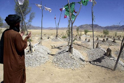 Un familiar de las víctimas muertas en un bombardeo estadounidense reza frente al cementerio en la aldea de Kakrakai, en el distrito de Dehrawad Uruzgan, el 6 de julio de 2002. (AFP/ Banaras KHAN)