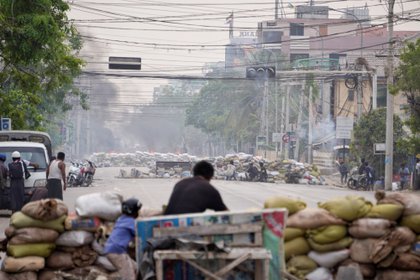 Los manifestantes se protegen detrás de las barricadas durante una manifestación contra el golpe militar en Mandalay, Myanmar, el 21 de marzo de 2021. REUTERS / Stringer / Foto de archivo