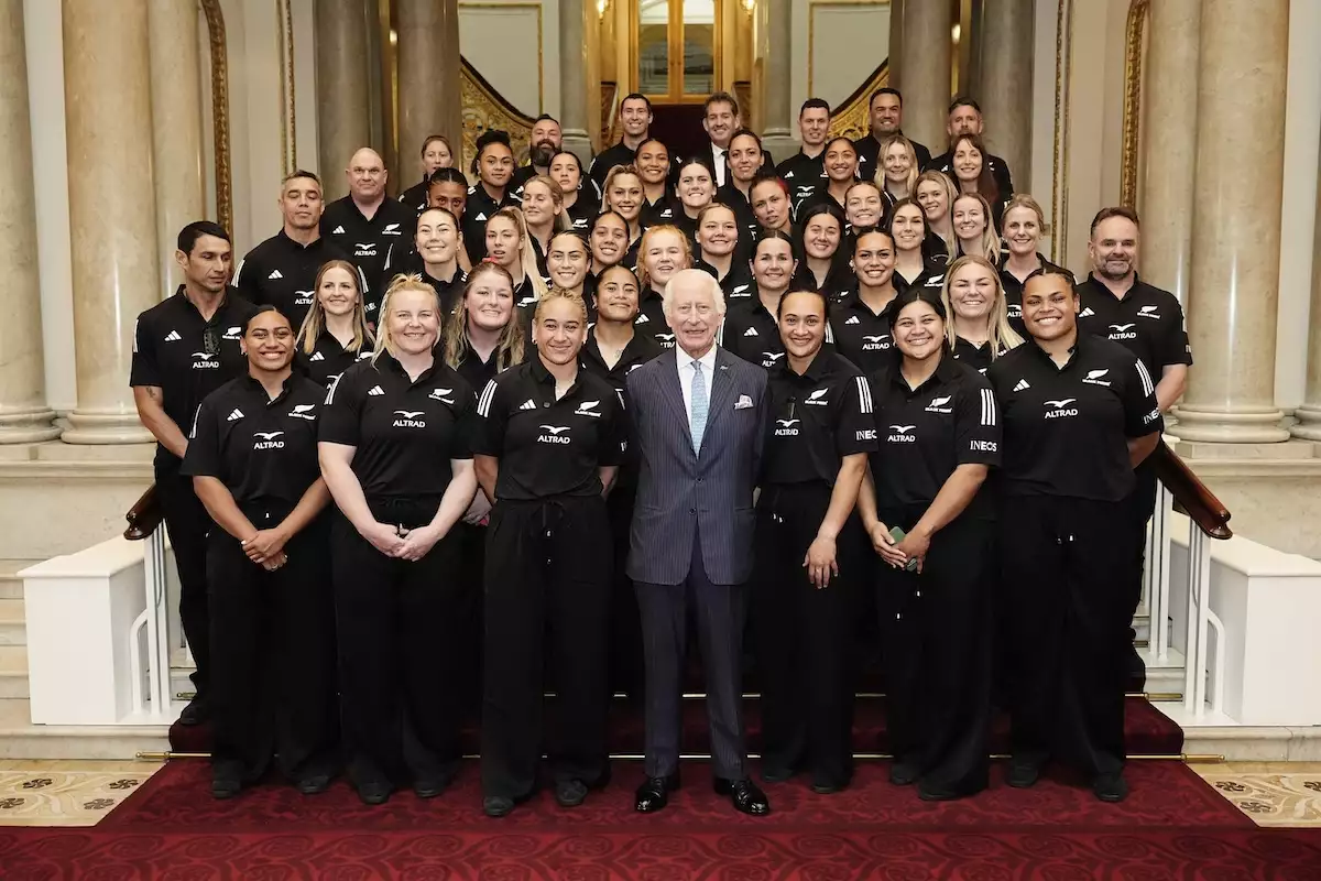 El rey Carlos III recibe un abrazo grupal del equipo de rugby femenil Black Ferns de Nueva Zelanda